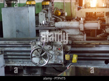 Vecchio tornio presso l'impresa, un tramonto arriva attraverso la finestra, il meccanismo Foto Stock