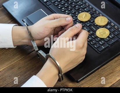 Gli uomini con le mani in mano in manette al computer, nei pressi giace crypto, minerario e hacking Foto Stock