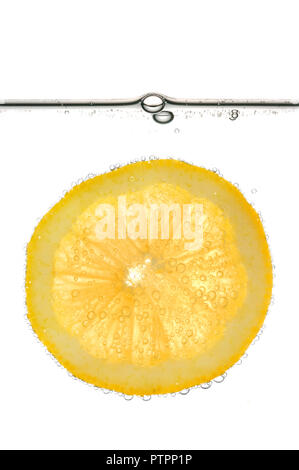Fetta di limone giallo in acqua con bolle. Isolato su sfondo bianco. Foto Stock