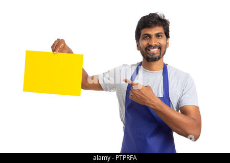 Ipermercato o supermercato indiano dipendente maschio indicando copyspace bianco su carta gialla con il dito indice isolato su bianco Foto Stock