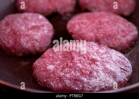 Tritare la carne biologica gli hamburger. La cottura in padella. Foto Stock