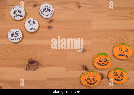 Funny Halloween Ghost i cookie. Emoticon zucche e fantasmi su una tavola di legno Foto Stock