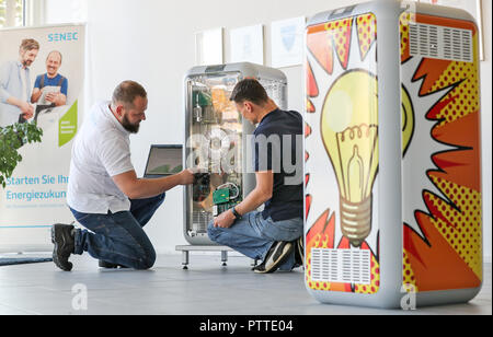 Leipzig, in Sassonia. 10 ottobre, 2018. I dipendenti Mario Sattler (l) e Reiner Bäurich discutere l'installazione di un avanzamento tecnico presso un deposito di batteria di Senec GmbH a Lipsia. Fondata nel 2009, la società di medie dimensioni con circa 140 dipendenti sviluppa e produce batterie sistemi di storage per le case e le imprese. Con questi sistemi di storage, ad esempio i proprietari di impianti a energia solare è in grado di garantire la loro alimentazione in gran parte autonomamente e senza elettricità dalla rete. Credito: Jan Woitas/dpa-Zentralbild/dpa/Alamy Live News Foto Stock