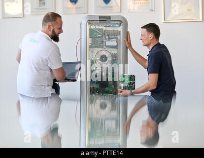 Leipzig, in Sassonia. 10 ottobre, 2018. I dipendenti Mario Sattler (l) e Reiner Bäurich discutere l'installazione di un avanzamento tecnico presso un deposito di batteria di Senec GmbH a Lipsia. Fondata nel 2009, la società di medie dimensioni con circa 140 dipendenti sviluppa e produce batterie sistemi di storage per le case e le imprese. Con questi sistemi di storage, ad esempio i proprietari di impianti a energia solare è in grado di garantire la loro alimentazione in gran parte autonomamente e senza elettricità dalla rete. Credito: Jan Woitas/dpa-Zentralbild/dpa/Alamy Live News Foto Stock