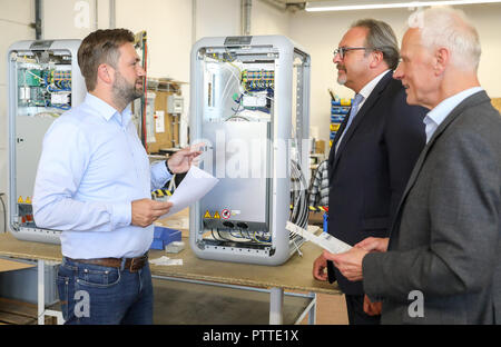 Leipzig, in Sassonia. 10 ottobre, 2018. Senec dipendente Ricardo Kopp (l) spiega Stefan Brangs (M, Segretario di Stato e SPD) e Wolf-Dietrich Rost (membro del Parlamento statale, CDU) la produzione della batteria dei sistemi di storage a Senec GmbH a Lipsia. Fondata nel 2009, la società di medie dimensioni con circa 140 dipendenti sviluppa e produce batterie sistemi di storage per le case e le imprese. Con questi sistemi di storage, ad esempio i proprietari di impianti a energia solare è in grado di garantire la loro alimentazione in gran parte autonomamente e senza elettricità dalla rete. Credito: Jan Woitas/dpa-Zentralbild/dpa/Alamy Live News Foto Stock