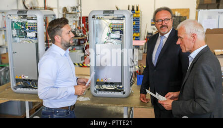 Leipzig, in Sassonia. 10 ottobre, 2018. Senec dipendente Ricardo Kopp (l) spiega Stefan Brangs (M, Segretario di Stato e SPD) e Wolf-Dietrich Rost (membro del Parlamento statale, CDU) la produzione della batteria dei sistemi di storage a Senec GmbH a Lipsia. Fondata nel 2009, la società di medie dimensioni con circa 140 dipendenti sviluppa e produce batterie sistemi di storage per le case e le imprese. Con questi sistemi di storage, ad esempio i proprietari di impianti a energia solare è in grado di garantire la loro alimentazione in gran parte autonomamente e senza elettricità dalla rete. Credito: Jan Woitas/dpa-Zentralbild/dpa/Alamy Live News Foto Stock