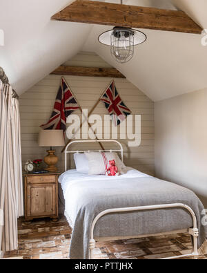 Un letto singolo con Union Jack e rigenerate assi di legno Foto Stock