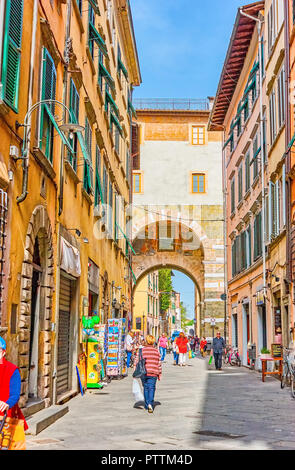 LUCCA, Italia - 30 Aprile 2013: il turista popolare via dello shopping Via Santa Croce con medievale restaurata Porta San Gervasio Gates sulla sua estremità, su Apri Foto Stock