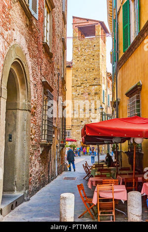 LUCCA, Italia - 30 Aprile 2013: la bella outdoor cafe con red ombrelloni in stretta strada medievale è il posto migliore dove andare a cena o a bere un c Foto Stock