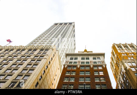 Guardando verso l'alto ornato edifici in stile liberty con una bandiera americana a volare su uno Foto Stock