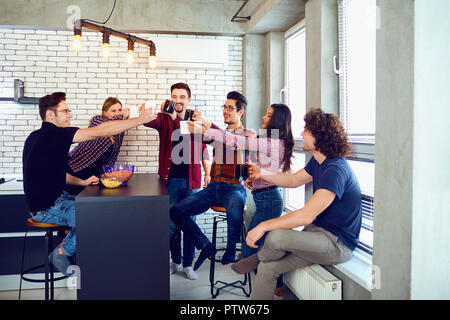 Gli amici hanno alzato la mano verso l'alto con la coppa. Foto Stock