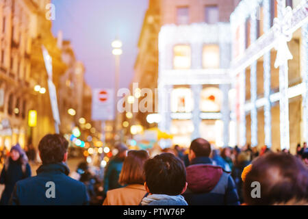 La folla di persone a piedi sulla strada trafficata Foto Stock