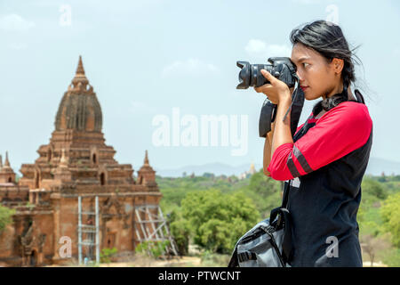 Il turista in Birmania è fotografare i monumenti storici. Giovane donna con telecamera in Myanmar. Foto Stock