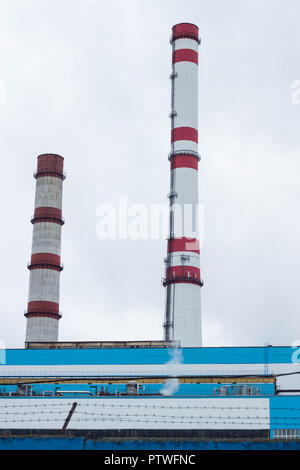 Due tubi di fabbrica contro il cielo, impianti Foto Stock