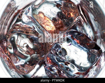 Close up di cubetti di ghiaccio nel bicchiere con riflessioni Foto Stock