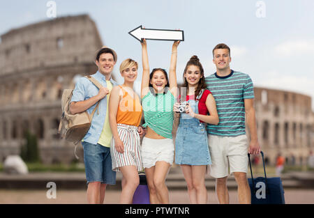 Amici con borse da viaggio e freccia sul Colosseo Foto Stock