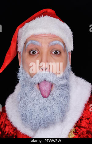 Allegro Santa Claus bloccato la sua lingua contro uno sfondo scuro Foto Stock