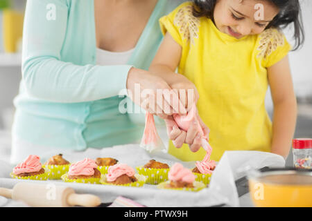 Madre e figlia tortini di cottura a casa Foto Stock