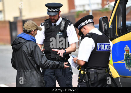 Merseyside funzionari di polizia effettuare un arresto e ricerca nell'Bootle area di Liverpool Foto Stock