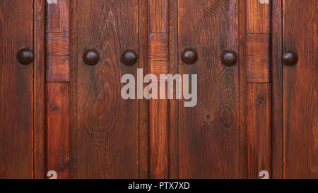 Ritagliato, ornato di ciliegio in legno marrone porta con perni di metallo, un medievale, rustico o antico disegno ornamentale, concetto di sfondo per la casa di proprietà Foto Stock