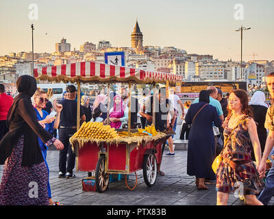 Istanbul, Turchia - 7 luglio 2018. I tutoli di mais in stallo in una strada del quartiere Eminonu, un ex quartiere di Istanbul, Turchia, con la Torre di Galata in backgroun Foto Stock