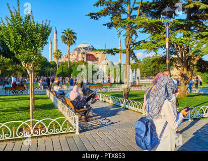 Istanbul, Turchia - 8 luglio 2018. Cittadini godendo una giornata di sole in Sultanahmet Park con la Hagia Sophia moschea in background. Istanbul. Foto Stock