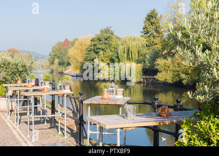 Altezza tavolo e sedie al di fuori di un pub lungo il fiume e si affaccia sul fiume Severn in Baja Sardinia, Worcestershire Foto Stock