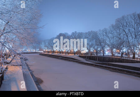 Fiume Aurajoki a notte invernale con il pupazzo di neve alberi sulle rive del fiume Foto Stock