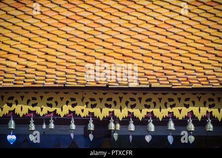 Bellissimo stile tailandese settentrionale del tempio di tegole del tetto e i dettagli di gronda con cute di piccole campane di bronzo. Decorativi in bronzo di piccole campane sono appesi al roo Foto Stock