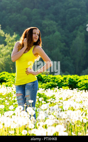 La donna su campo verde con dente di leone Foto Stock