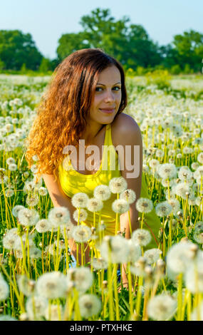 La donna su campo verde con dente di leone Foto Stock