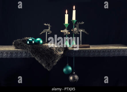 Decorazione di Natale elementi in caldi toni color turchese contro uno sfondo scuro. In aggiunta al turchese, marrone scuro, legno, pelliccia e argento vecchio creare Foto Stock