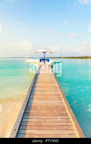 Il molo in legno, jetty al Tropical Island resort di prima mattina, Maldive. Vacanze e Turismo Concept Foto Stock