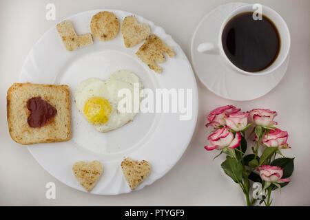 La prima colazione per gli amanti, uova strapazzate, caffè, rose Foto Stock