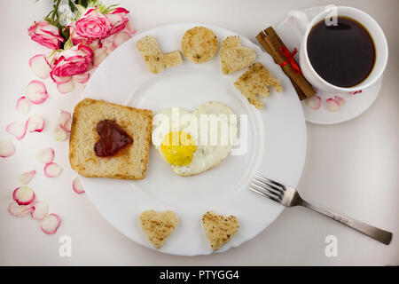 La prima colazione per gli amanti, uova strapazzate, caffè, rose Foto Stock