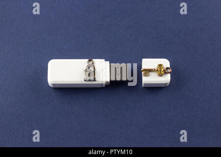 White flash drive su uno sfondo blu, la chiave e la serratura Foto Stock