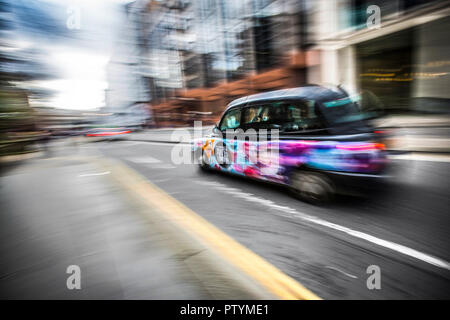 British taxi accelerando nel centro di Londra. Volutamente sfocati per convogliare la velocità. Motion Blur effetto. Foto Stock