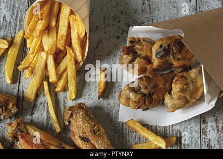 Arrosto di ali di pollo con patate fritte da sopra closeup Foto Stock