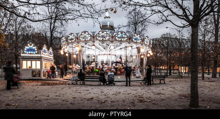 I Giardini delle Tuileries, Parigi, Francia. 18 Novembre, 2018. I genitori guardare i bambini giro sulla giostra su un freddo inverno di pomeriggio a Les Tuileries Foto Stock