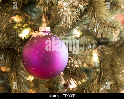 Viola palla di Natale con i fiocchi di neve su albero di pino all'aperto Foto Stock