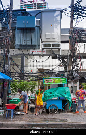 Tradizionale cibo di strada i venditori, con appeso i fili elettrici al di sopra di essi. Bangkok, Thailandia Foto Stock