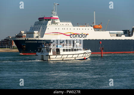 Commodore buona volontà un canale trasversale nave commerciale inserendo il porto di Portsmouth, England Regno Unito. In attendace un tour del porto con imbarcazione di passeggeri Foto Stock