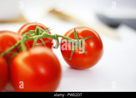 Ancora in vita di freschi pomodori rossi in cucina con peduncolo verde Foto Stock