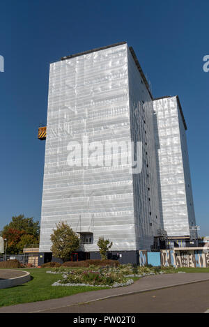 Highrise blocco di appartamenti e monolocali coperti in fogli di plastica per la protezione dagli agenti atmosferici mentre i lavori viene effettuata sull'edificio, Gosport, Regno Unito Foto Stock