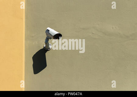 Videocamera di sicurezza su una verde e giallo facciata della casa Foto Stock