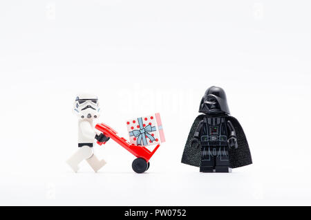 Lego Storm Trooper spingendo il carrello con scatola regalo mentre Darth Vader guardando. Foto Stock