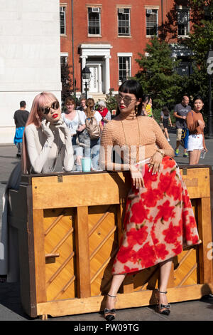 Due belle sottili modelli giapponesi e curiosi di Washington Square Park nel Greenwich Village di New York City su un Photo Shoot. Foto Stock