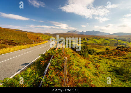 Strada vuota sull isola di Skye che conduce verso il nero Cuillin montagne in distanza, Scozia Foto Stock