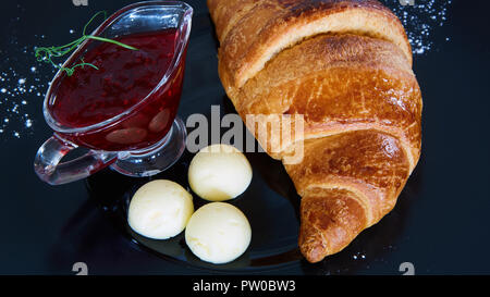 Vista dettagliata del burro, marmellata e cornetti freschi Foto Stock