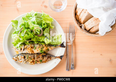 Due appena le Sardine alla brace servite con insalata di lattuga e pane Foto Stock